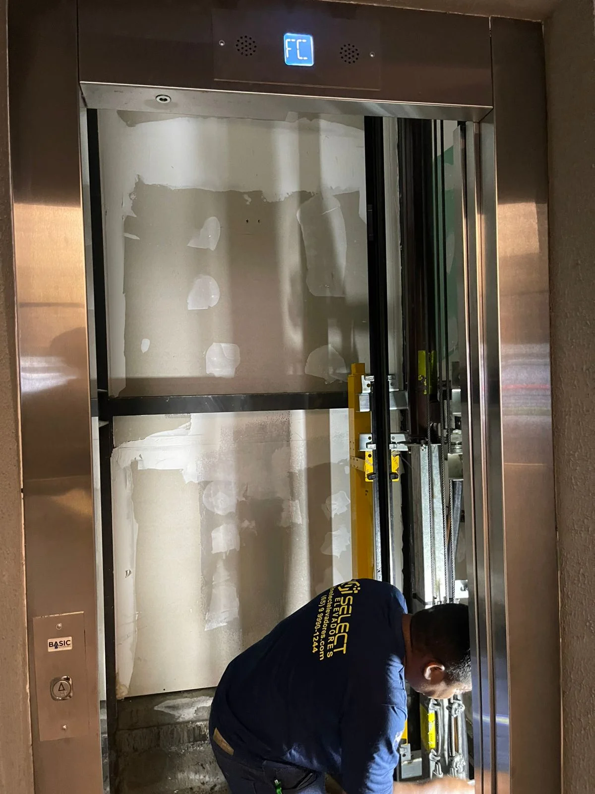 Técnico realizando instalação em cabine de elevador