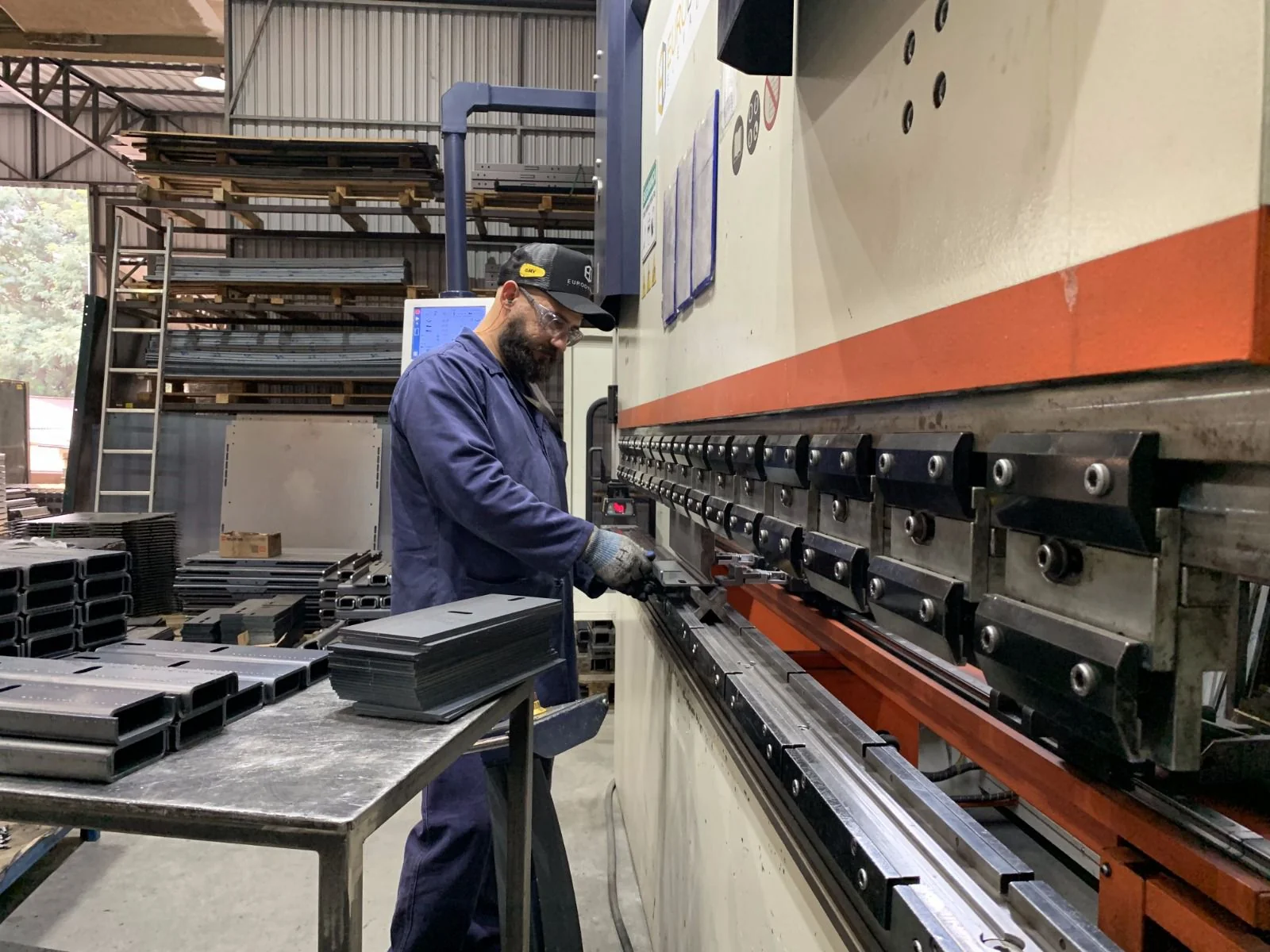 Operador Select em dobradeira CNC fabricando peça do elevador