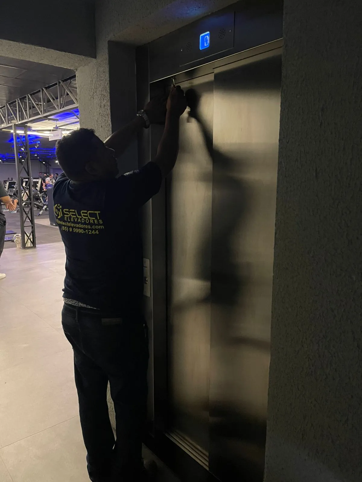 Técnico Select ajustando porta de elevador em atendimento